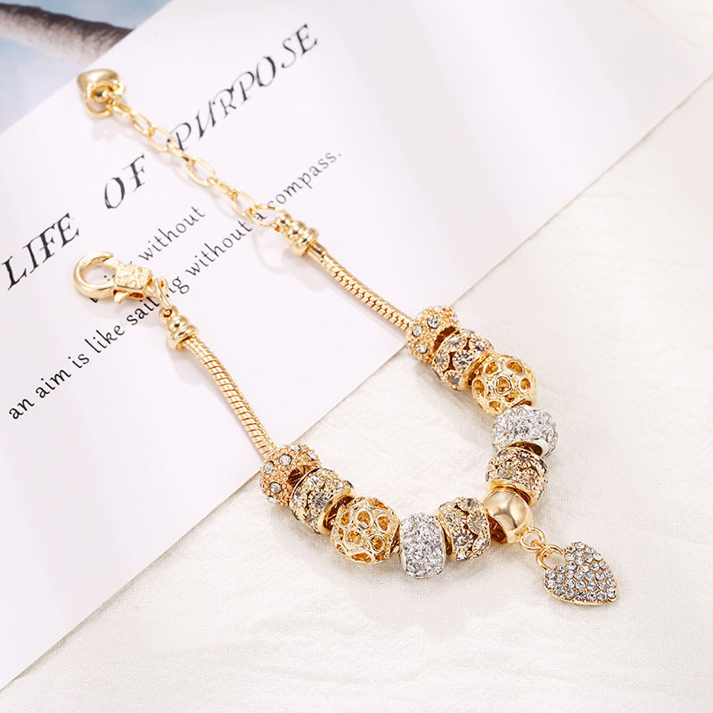 Charming gold bracelet: intricate charms and crystals for a touch of elegance. A&S Collection