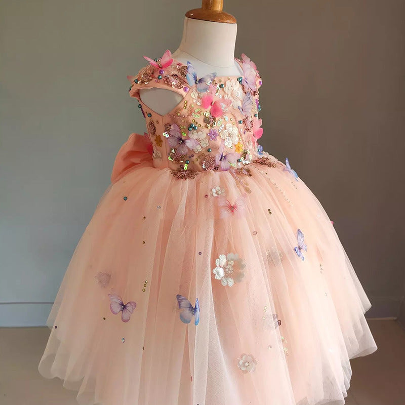 Elegant peach flower girl dress with butterfly and floral embellishments. A&S Collection
