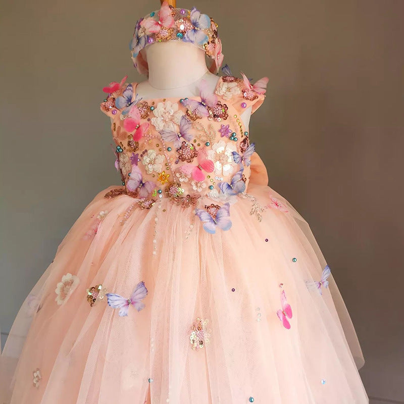 Elegant peach flower girl dress with butterfly and floral embellishments. A&S Collection