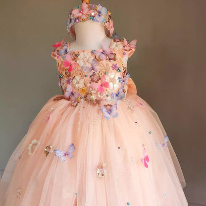 Elegant peach flower girl dress with butterfly and floral embellishments. A&S Collection