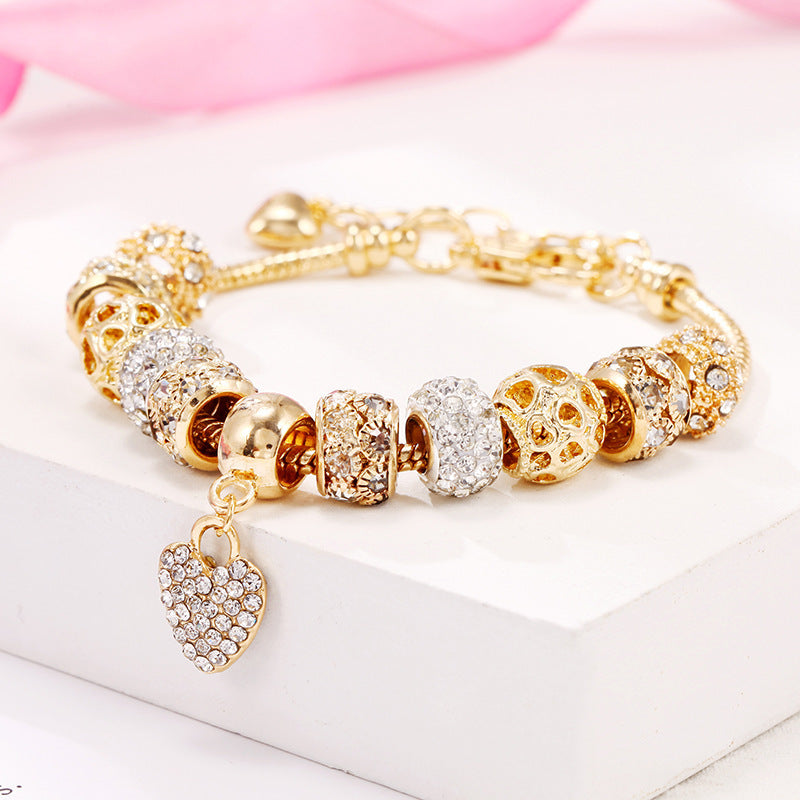 Charming gold bracelet: intricate charms and crystals for a touch of elegance. A&S Collection