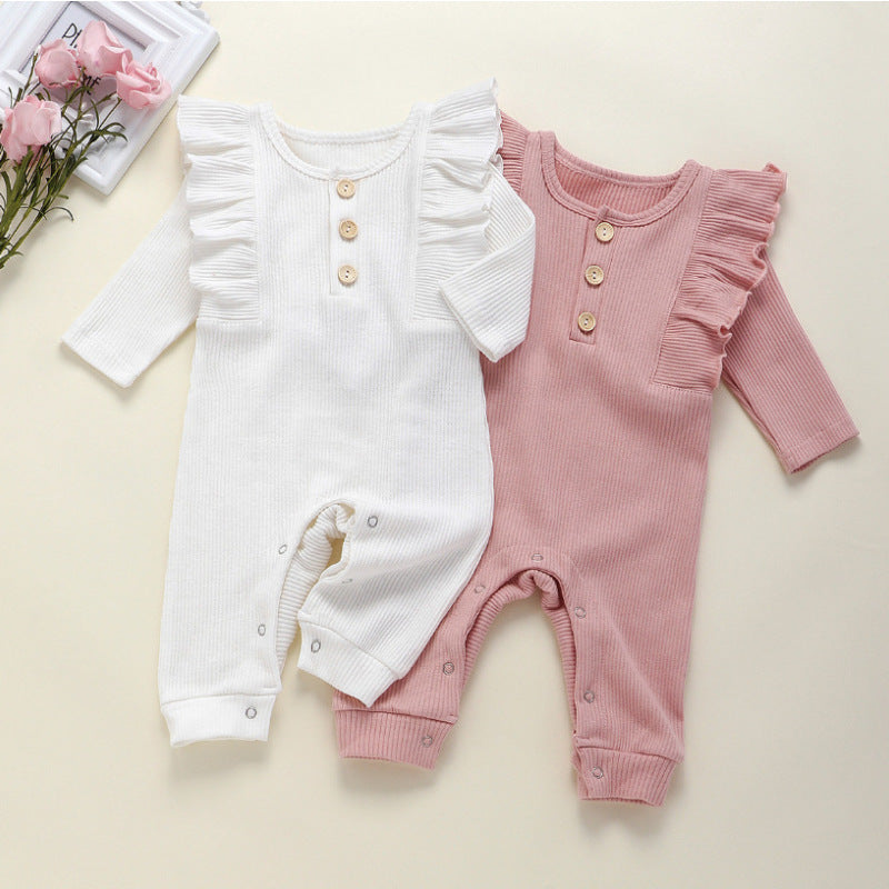 This adorable long sleeve ruffle romper features ribbed fabric with ruffled shoulders and wooden button accents, perfect for baby's cute and comfy style. A&S Collection