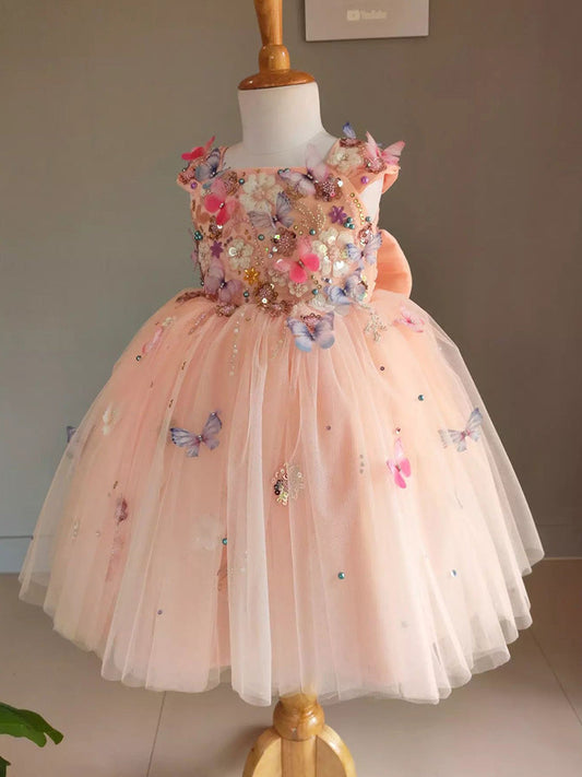 Elegant peach flower girl dress with butterfly and floral embellishments. A&S Collection