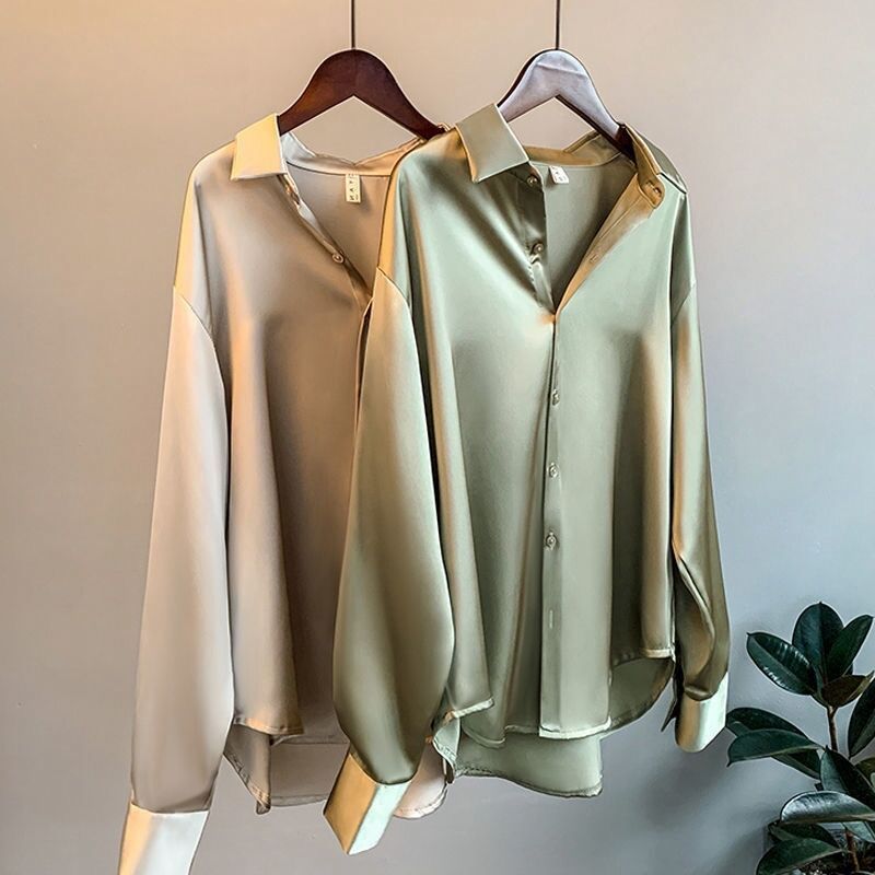 Elegant silk blouses in white, beige, olive, and black, neatly hung on wooden hangers A&S Collection