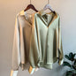 Elegant silk blouses in white, beige, olive, and black, neatly hung on wooden hangers A&S Collection