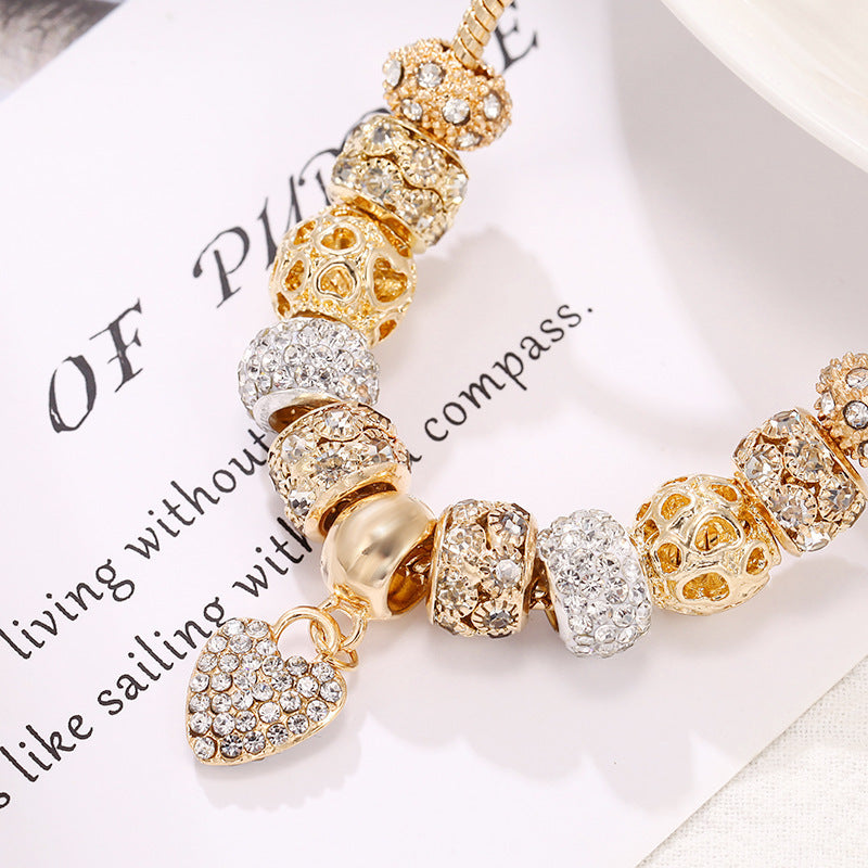 Charming gold bracelet: intricate charms and crystals for a touch of elegance. A&S Collection