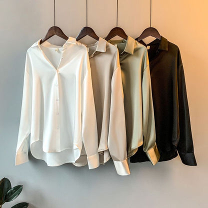 Elegant silk blouses in white, beige, olive, and black, neatly hung on wooden hangers A&S Collection