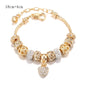 Charming gold bracelet: intricate charms and crystals for a touch of elegance. A&S Collection